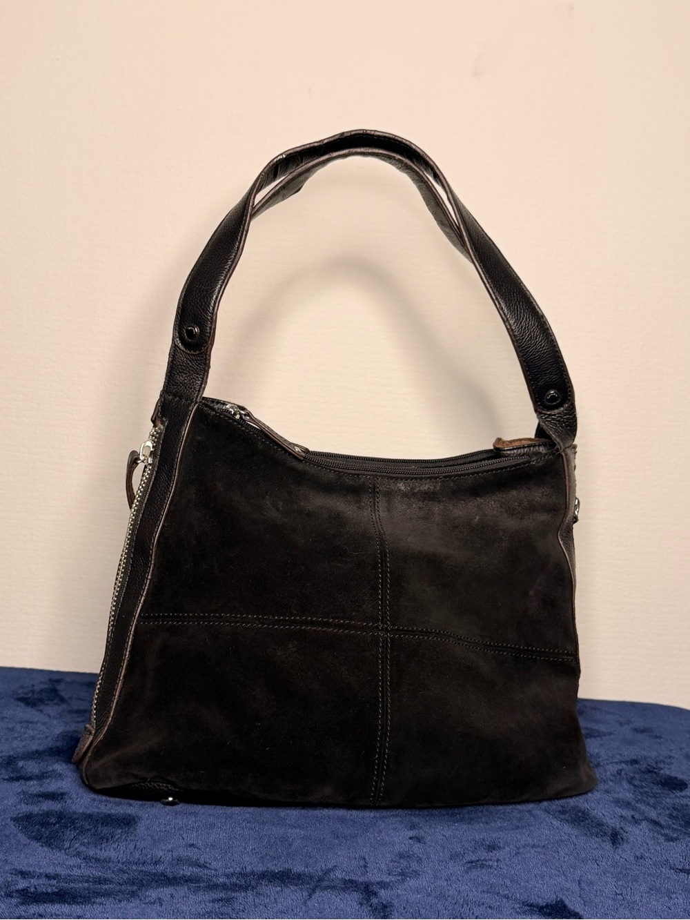 Tignanello black suede hobo shoulder bag featuring side zippers for expansion